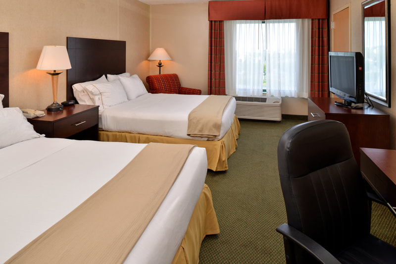 a picture of the Holiday Inn Express & Suites in Ocean City, MD showing a guest room with two queen size beds