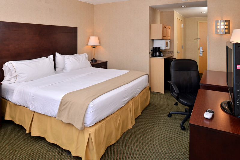 a picture of the Holiday Inn Express & Suites in Ocean City, MD showing a guest room with one king sized bed