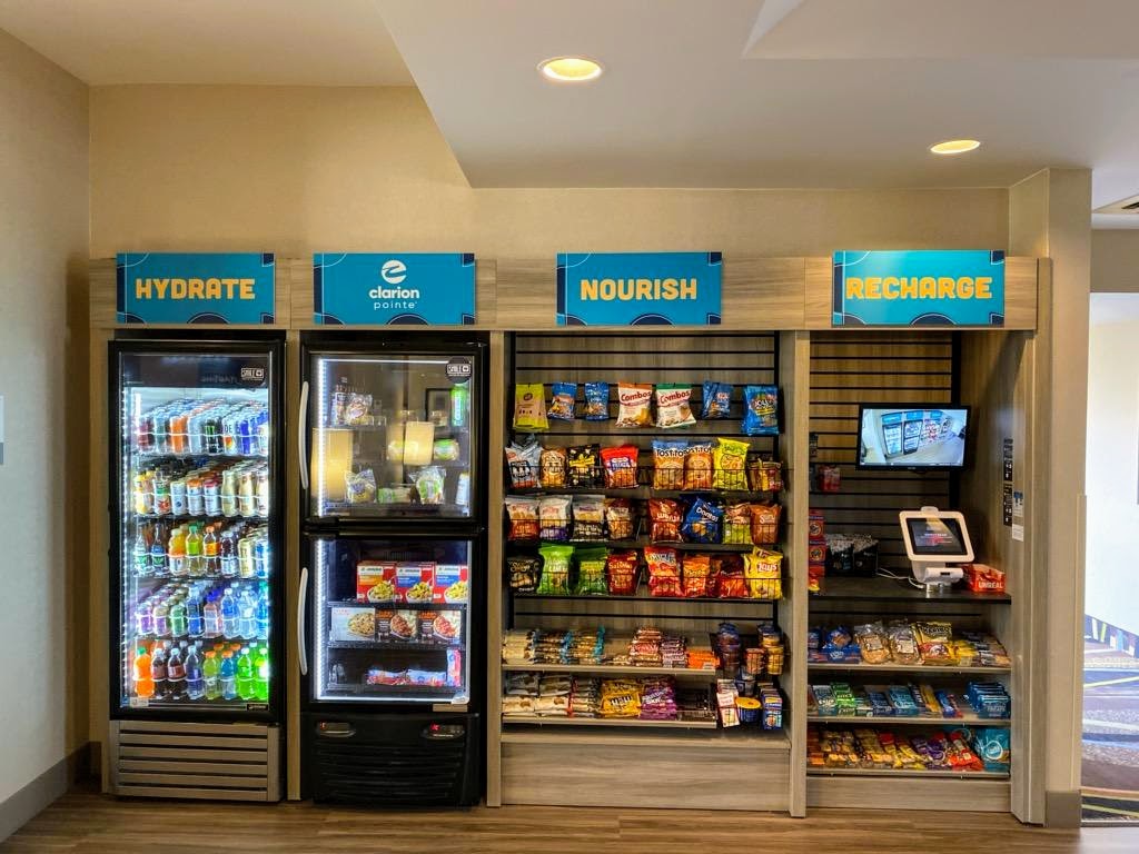 a picture of the lobby convenience store at the newly renovated Clarion Pointe Harrisonburg featuring self checkout, craft beers, and wine; in addition to sodas, snacks, ice cream, sundries, and more