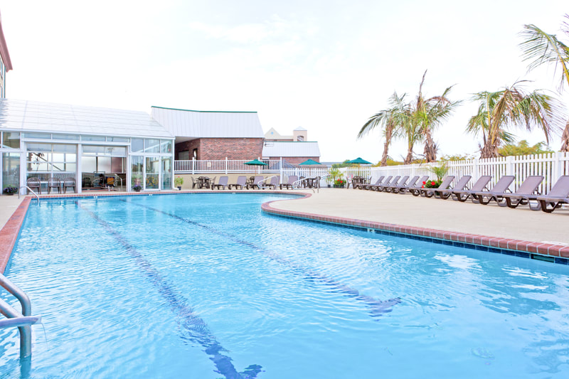 a picture of the Holiday Inn Express & Suites in Ocean City, MD showing the outdoor pool and indoor pool with sundeck