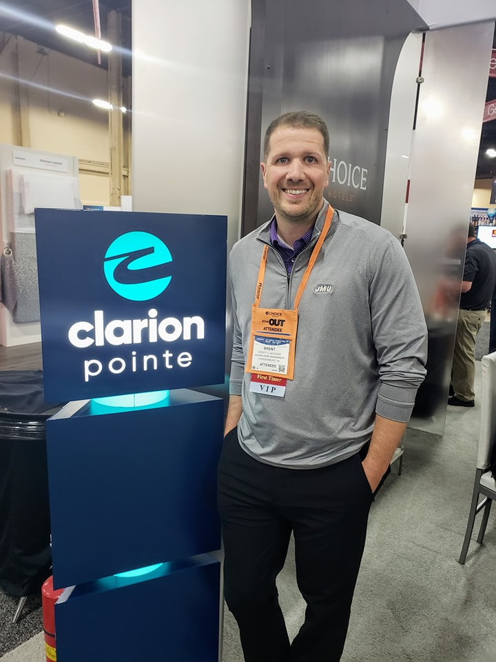 Picture of Jackson Hotel Management President Brent C Jackson standing next to a clarion pointe sign.  Jackson Hotel Management operates one of the very first clarion pointe hotels. 